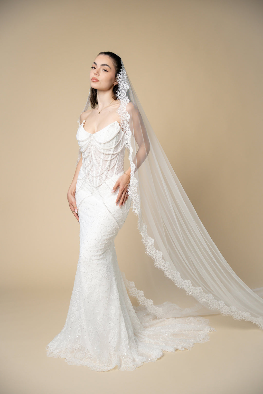 Bride wearing the Adella cathedral wedding veil with luxurious lace, pearls, sequins and eyelash lace edging by Aoura Veil