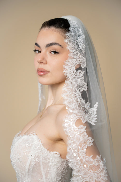 Close-up of Beverly cathedral wedding veil with floral sequined eyelash lace and fringed edges