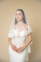 Bride wearing the Clara cathedral wedding veil featuring delicate 3D floral lace with eyelash fringe along the edges by Aoura Veil