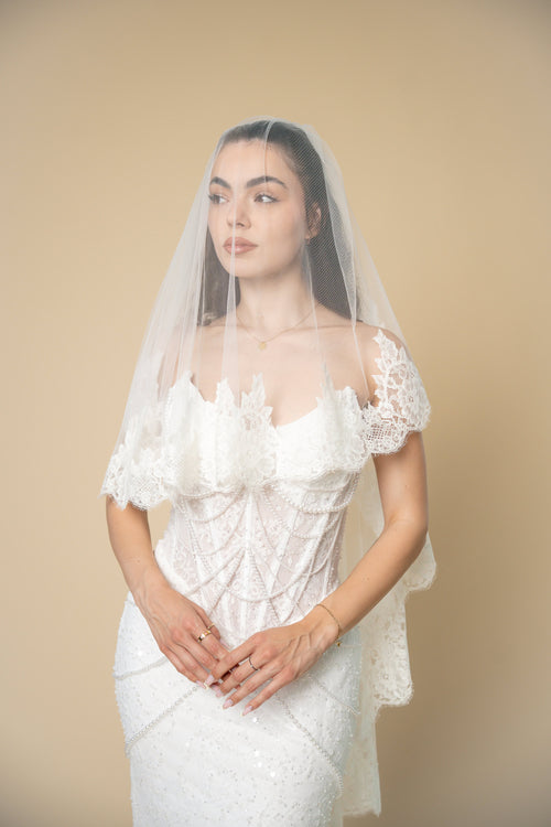 Bride wearing the Clara cathedral wedding veil featuring delicate 3D floral lace with eyelash fringe along the edges by Aoura Veil