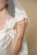 Close-up of the Clara wedding veil showcasing handcrafted 3D floral lace with delicate eyelash fringe on the veil edge by Aoura Veil