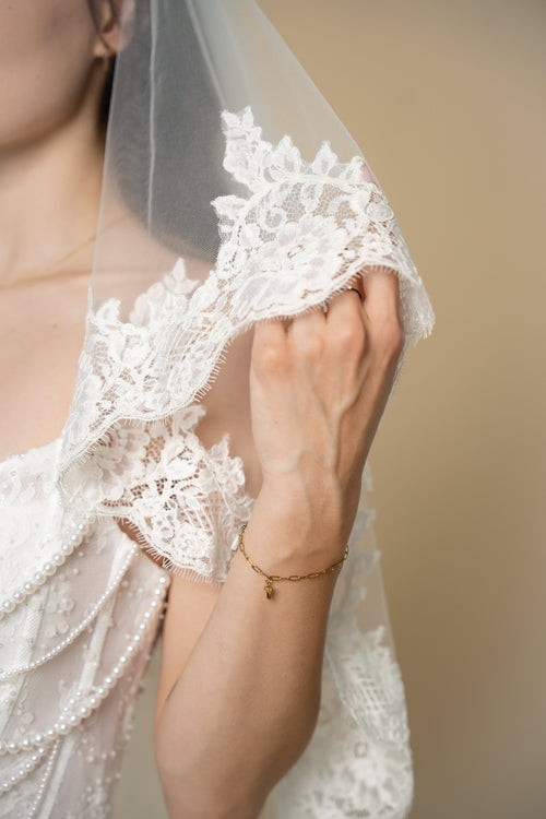 Close-up of the Clara wedding veil showcasing handcrafted 3D floral lace with delicate eyelash fringe on the veil edge by Aoura Veil