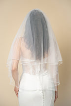 Back view of Darla short wedding veil featuring a delicate X-pattern edge handcrafted with pearls and crystals