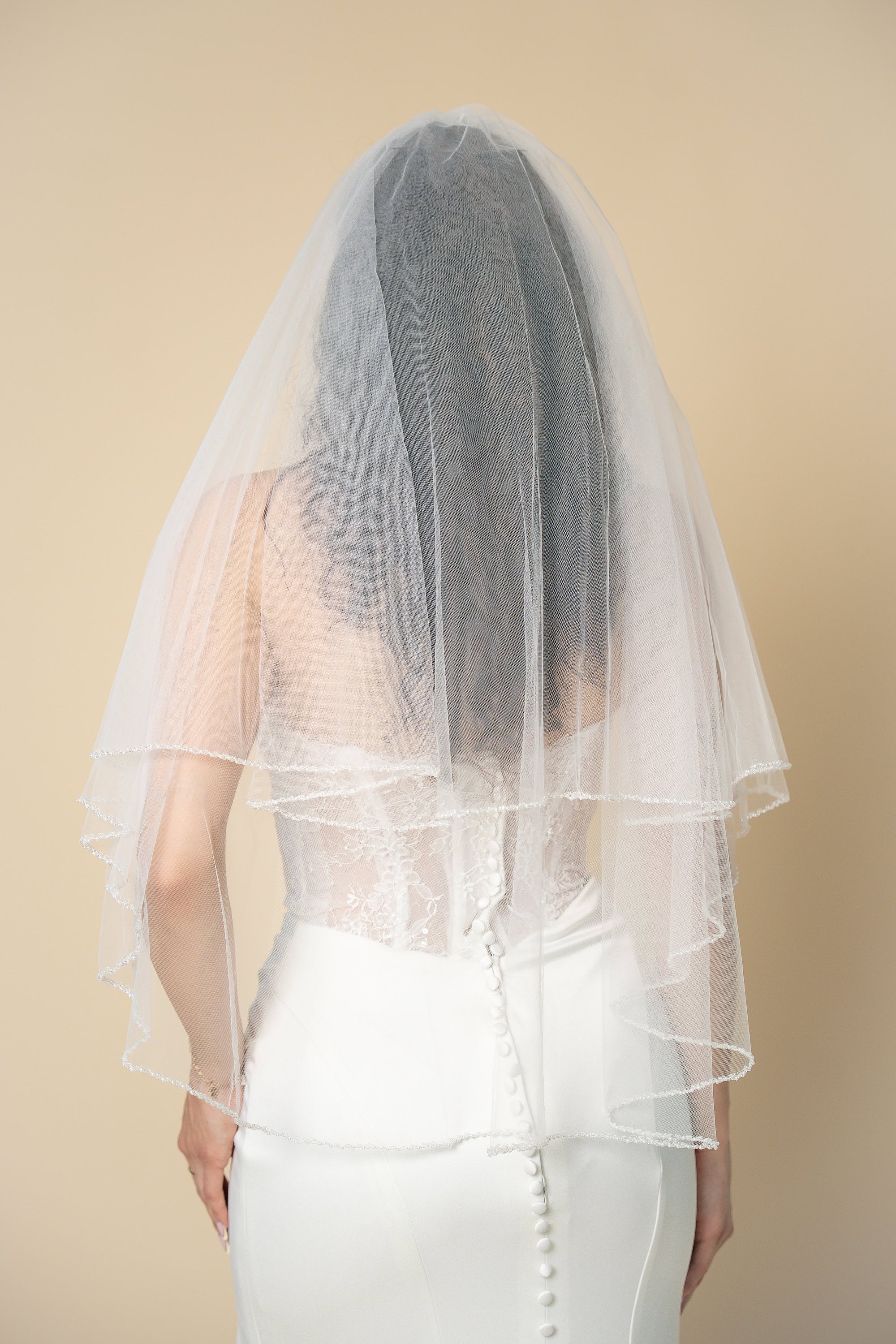 Back view of Darla short wedding veil featuring a delicate X-pattern edge handcrafted with pearls and crystals