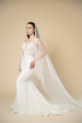 Full-length view of the Elora cathedral wedding veil featuring vertical pearl and crystal detailing for a luxurious bridal look by Aoura Veil