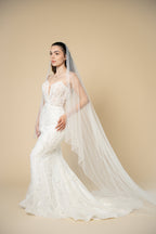 Full-length view of the Elora cathedral wedding veil featuring vertical pearl and crystal detailing for a luxurious bridal look by Aoura Veil