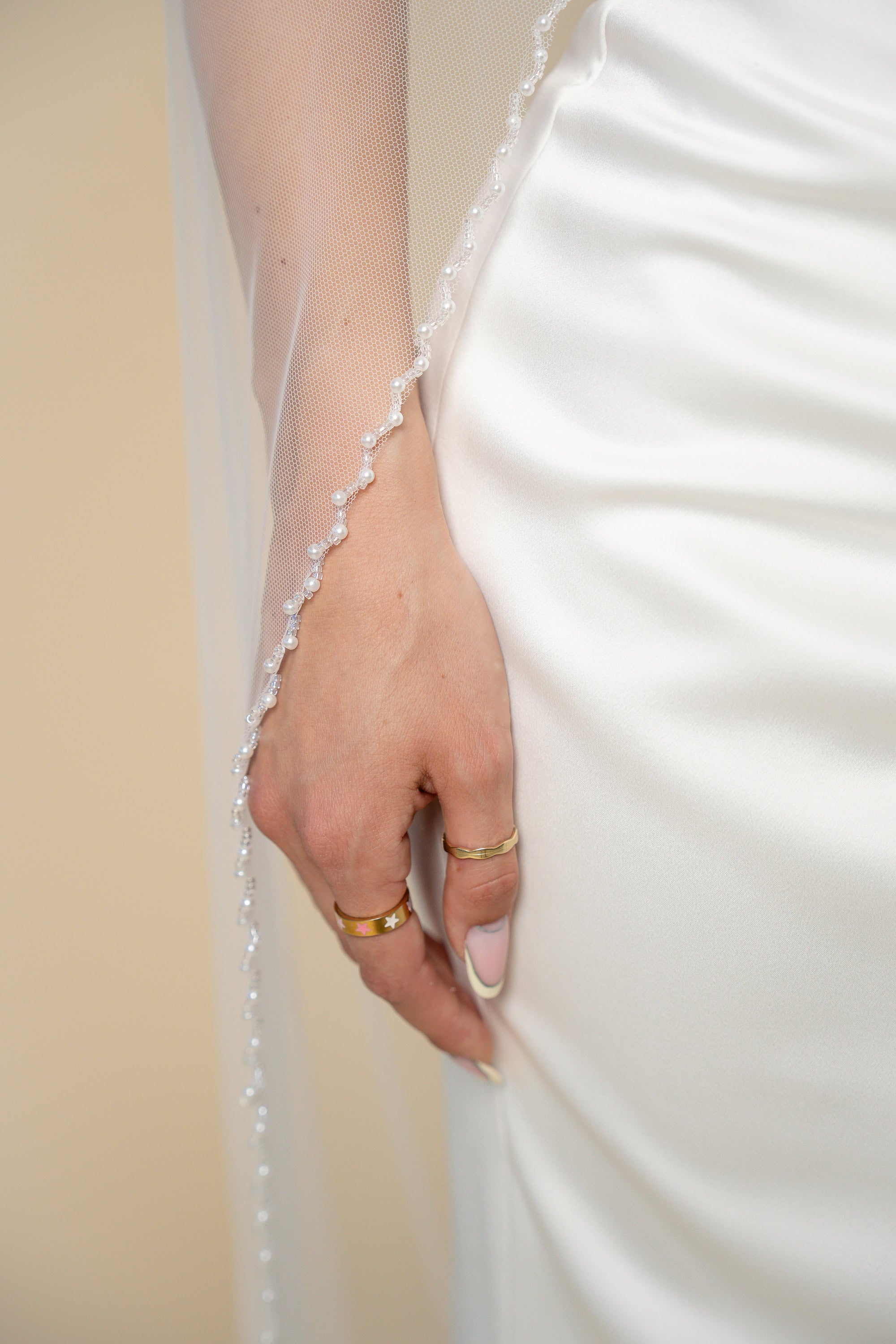 Close-up of Emira cathedral bridal veil with hand-applied pearls and crystal edging