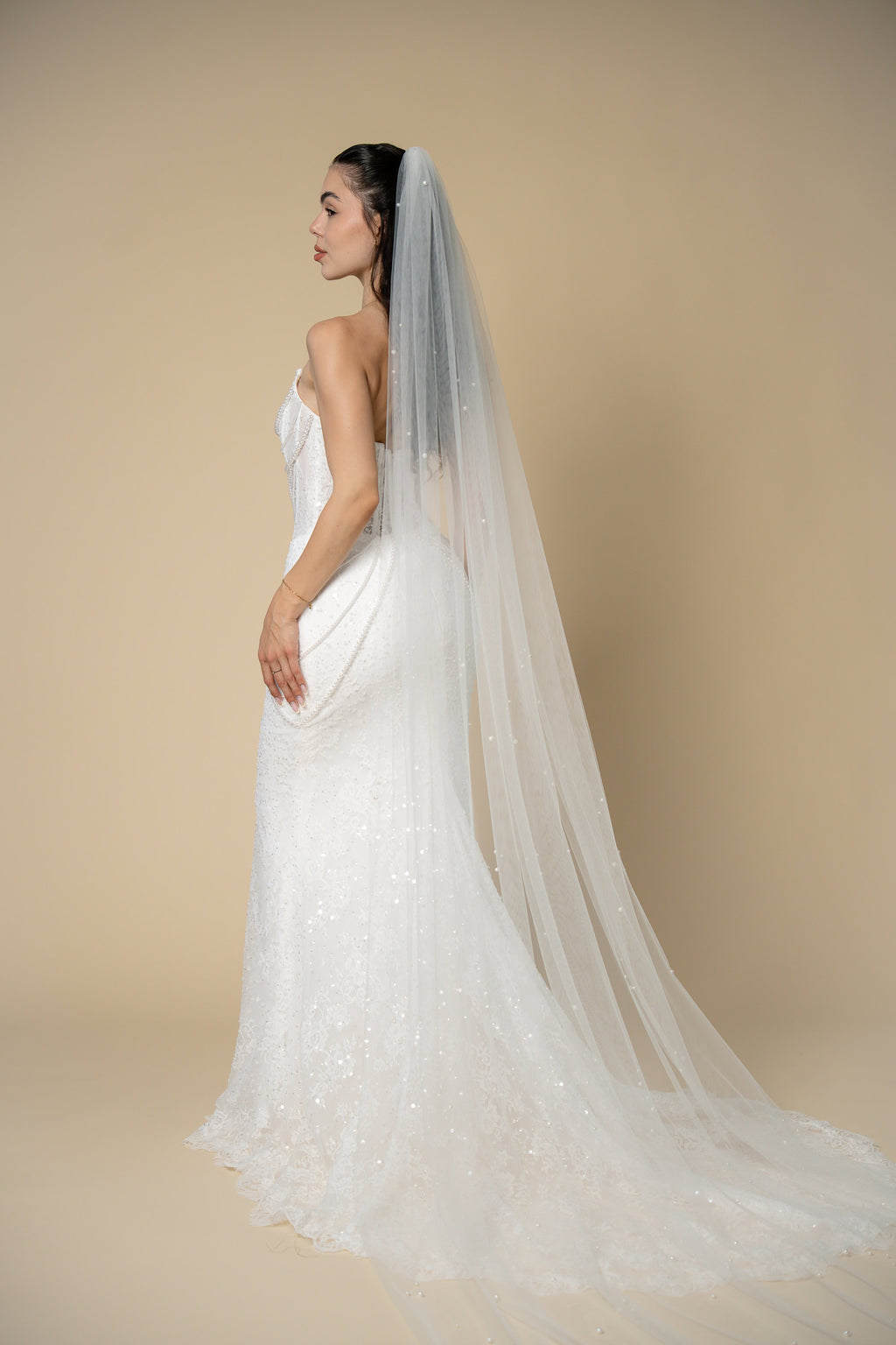 Back view of the Poppy pearl cathedral wedding veil featuring delicate pearl clusters throughout the veil by Aoura Veil
