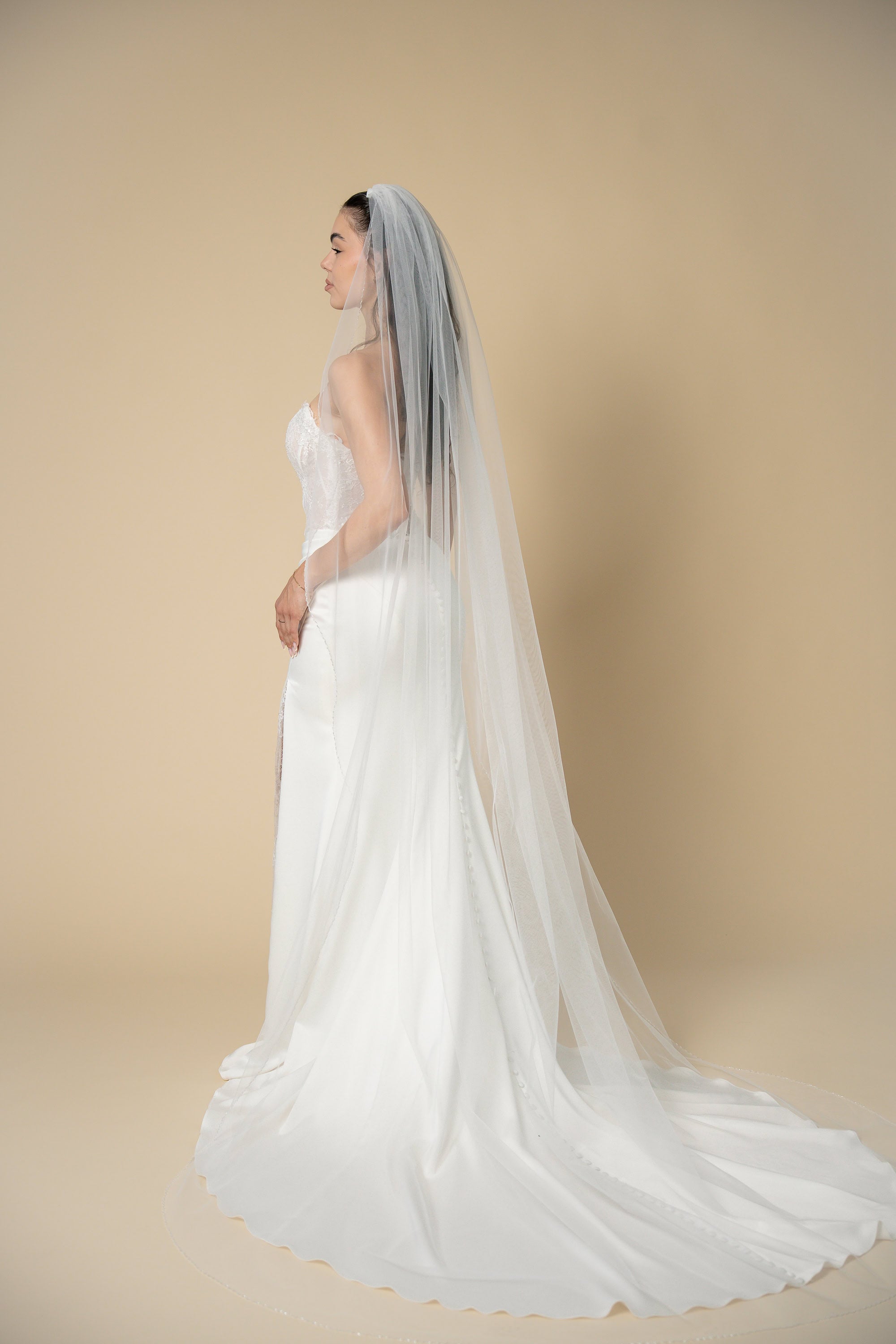 Back view of Sindy cathedral wedding veil featuring a delicate wavy edge adorned with transparent crystals handcrafted by Aoura Veil