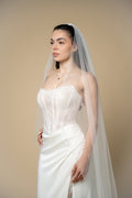 Sindy cathedral wedding veil featuring a delicate wavy edge adorned with transparent crystals handcrafted by Aoura Veil