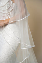 Close-up of the Vivian bridal veil highlighting the delicate white satin trim along the edge by Aoura Veil